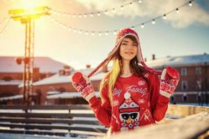 mooie jonge vrouw op de ijsbaan, glimlachend in de zon foto