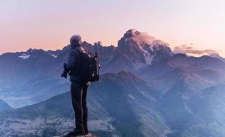 professionele fotograaf maakt foto's met grote camera op de top van de rots foto