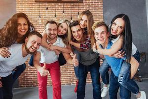 groepsportret van multi-etnische jongens en meisjes met kleurrijke modieuze kleding met vriend poseren op een bakstenen muur, stedelijke stijl mensen die plezier hebben, concepten over jeugd saamhorigheid levensstijl foto