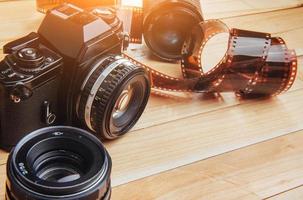 oude filmcamera en een rolletje op hout foto