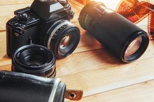 oude filmcamera en een rolletje op hout foto