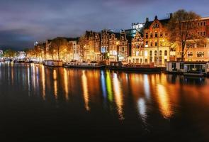 nacht uitzicht op de stad van amsterdamse gracht, typisch nederlandse huizen en boa foto