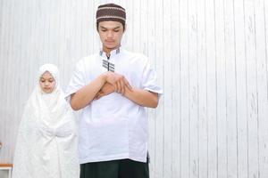 jong koppel moslim met hand in borst doet samen salat foto