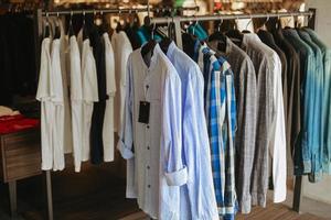 verschillende overhemden die aan hangerkleding in de winkel hangen foto