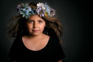 schattig klein meisje met bloemenkrans foto