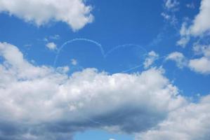 twee vliegtuigen maken hart op blauwe lucht met misteffect foto