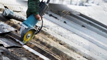 arbeiders gebruiken slijpstenen, snijden, bevestigen stalen daken. foto