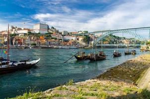 portugal, stadslandschap porto, een groep gele houten boten met wijnvaten op de douro-rivier foto