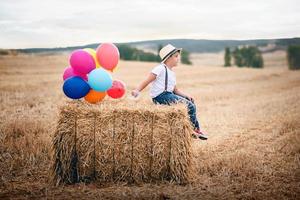 jongen met ballonnen in het veld foto