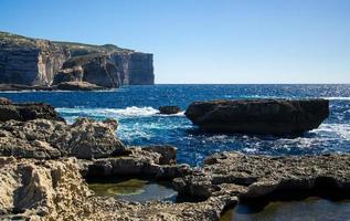 schimmel en gebla rotskliffen bij azuurblauw venster, gozo-eiland, malta foto