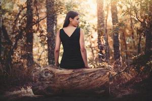 portret van mooie jonge vrouw die in het veld zit foto