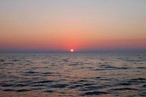 zonsondergang op het strand, mooie grijze en oranje wolk zomer strand, zee en zand foto