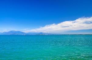 gardameer azuurblauw turkoois wateroppervlak met uitzicht op het monte baldo gebergte foto