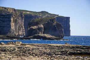 schimmel en gebla rotskliffen bij azuurblauw venster, gozo-eiland, malta foto