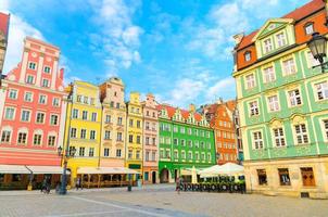 rij kleurrijke traditionele gebouwen met veelkleurige gevels en straatlantaarn op het geplaveide marktplein van rynek foto