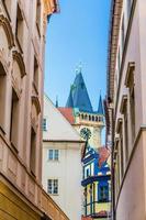 sprookjesachtig praag, smalle straatjes van praag, top van de toren van het oude stadhuis foto