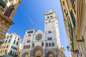 gevel van de kathedraal van san lorenzo katholieke kerk op piazza san lorenzo plein tussen gebouwen in het historische centrum van de oude europese stad genua foto