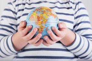 handen van een kind met de planeet aarde foto
