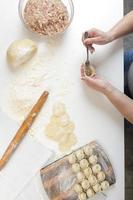 zelfgemaakte dumplings in de keuken zonder versieringen. dumplings maken met varkensgehakt, rundvlees en kip foto