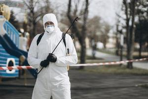 reiniging en desinfectie in het stadscomplex te midden van de coronavirusepidemie professionele teams voor desinfectie-inspanningen infectiepreventie en controle van epidemisch beschermend pak en masker foto