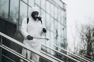 reiniging en desinfectie in het stadscomplex te midden van de coronavirusepidemie professionele teams voor desinfectie-inspanningen infectiepreventie en controle van epidemisch beschermend pak en masker foto