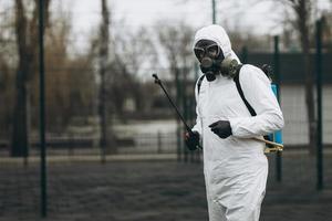 reiniging en desinfectie in het stadscomplex te midden van de coronavirusepidemie professionele teams voor desinfectie-inspanningen infectiepreventie en controle van epidemisch beschermend pak en masker foto