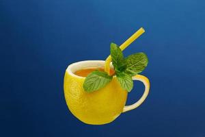 een kopje thee gemaakt van natuurlijke citroen met muntblaadjes. creatieve compositie rond het thema natuurlijke thee foto