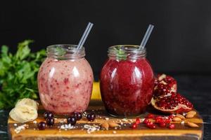 vers bereide smoothies van banaan met granaatappel en banaan met braambes in fles. dieet, gezonde levensstijl foto