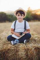 jongen die een boek in het veld leest foto