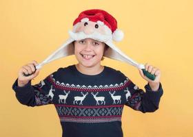 glimlachend kind dat de hoed van de kerstman draagt foto