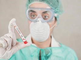coronavirus.medical werknemer arts die reageerbuis met bloed vasthoudt voor 2019-ncov, achtergrondvervaging foto
