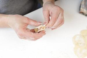 zelfgemaakte dumplings in de keuken zonder versieringen. dumplings maken met varkensgehakt, rundvlees en kip foto