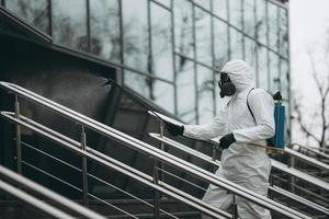 reiniging en desinfectie in het stadscomplex te midden van de coronavirusepidemie professionele teams voor desinfectie-inspanningen infectiepreventie en controle van epidemisch beschermend pak en masker foto