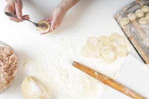 zelfgemaakte dumplings in de keuken zonder versieringen. dumplings maken met varkensgehakt, rundvlees en kip foto