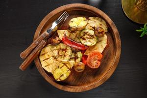 set van gebakken groenten courgette tomaat aardappelen paprika op houten plaat foto