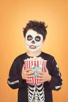 gelukkig halloween.grappig kind in een skeletkostuum met popcorn foto