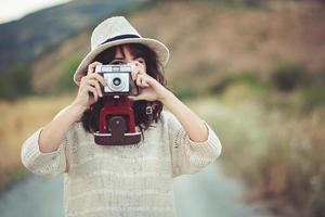 lachend meisje met camera in het veld foto