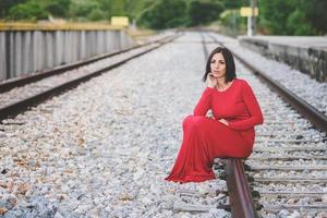 peinzende vrouw zittend op de treinrails foto