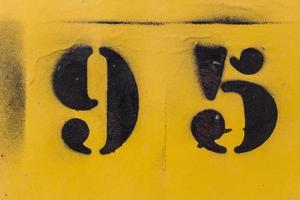 zwart nummer 95 stencil geschilderd op gele achtergrond foto