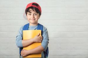 gelukkig kind met rugzak en met notitieboekje, terug naar school foto