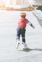 kind buiten rolschaatsen in park foto