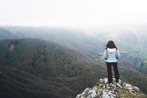 peinzend meisje op de top van de berg foto