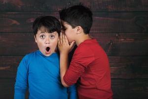 portret van twee jongens die geheim fluisteren foto