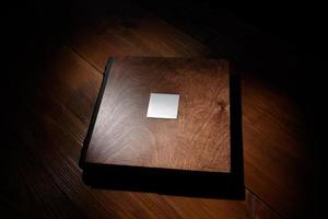 fotoboek in een houten omslag op een houten tafel. hard licht foto