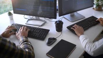jonge startup-programmeurs die aan een bureau zitten en aan het computerscherm werken voor het ontwikkelen van programmering en codering om een oplossing te vinden voor het probleem van een nieuwe applicatie foto