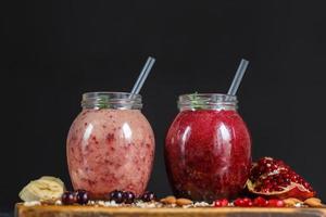 vers bereide smoothies van banaan met granaatappel en banaan met braambes in fles. dieet, gezonde levensstijl foto