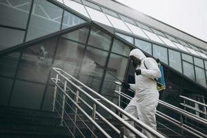 reiniging en desinfectie in het stadscomplex te midden van de coronavirusepidemie professionele teams voor desinfectie-inspanningen infectiepreventie en controle van epidemisch beschermend pak en masker foto