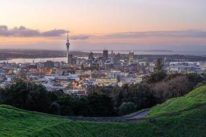 de stadshorizon van auckland met de hemeltoren van auckland van mt. eden bij zonsondergang nieuw-zeeland foto