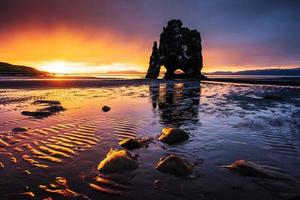 hvitserkur 15 m hoogte. is een spectaculaire rots in de zee aan de noordkust van ijsland. deze foto weerspiegelt in het water na de middernachtzonsondergang.