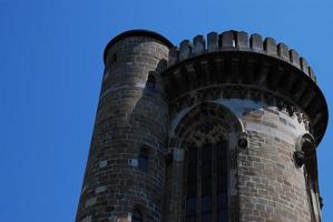 oude toren van een kasteel met kantelen en blauwe lucht foto
